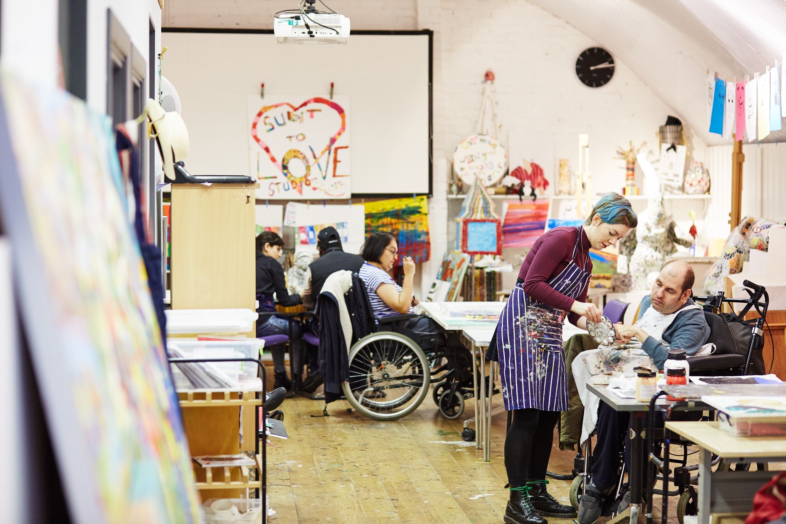 A group of people painting in a brightly lit studio