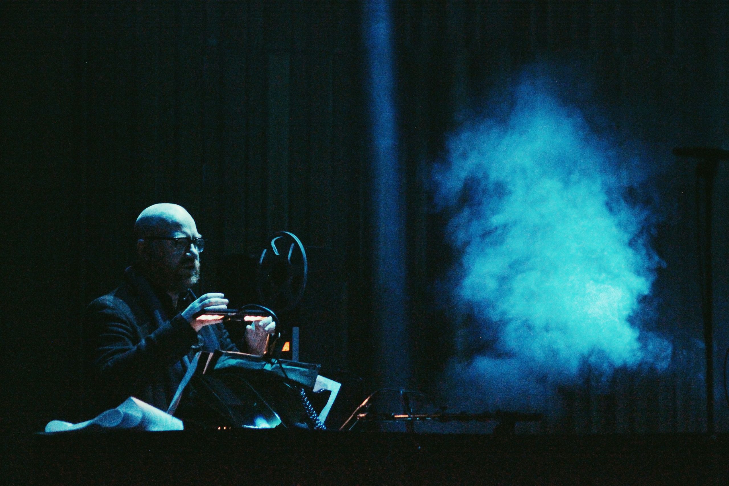 Johann Johannsson in a dark concert room with some blue fog