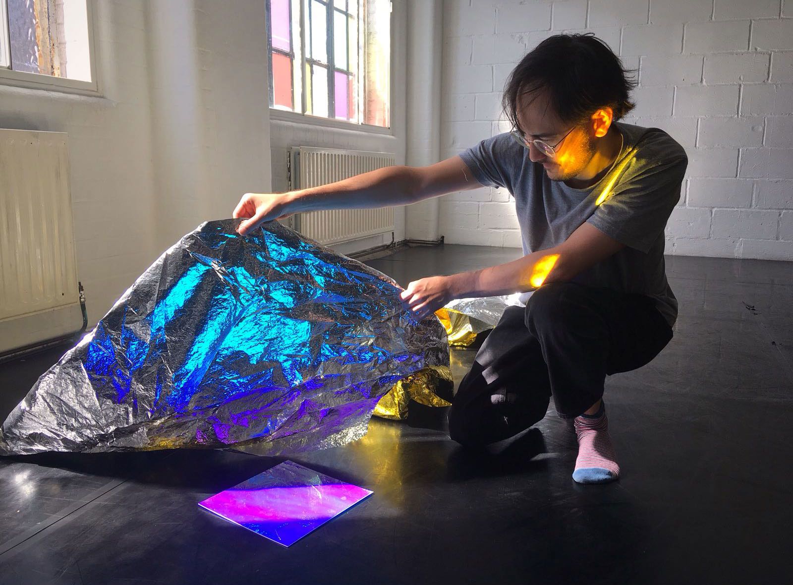 photo of man holding thermal blanket in a room