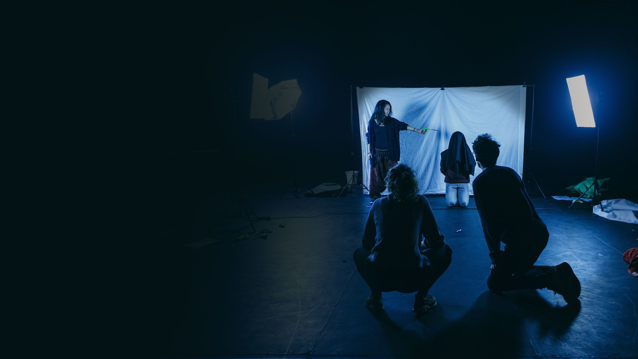 four people in a dark room with some fluorescent lights