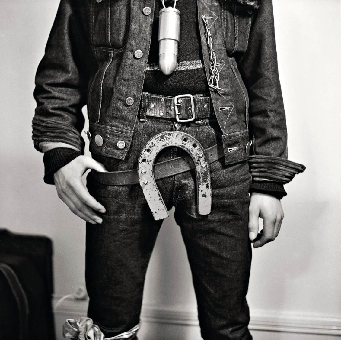 The lower half of a man's body showing a horseshoe belt buckle