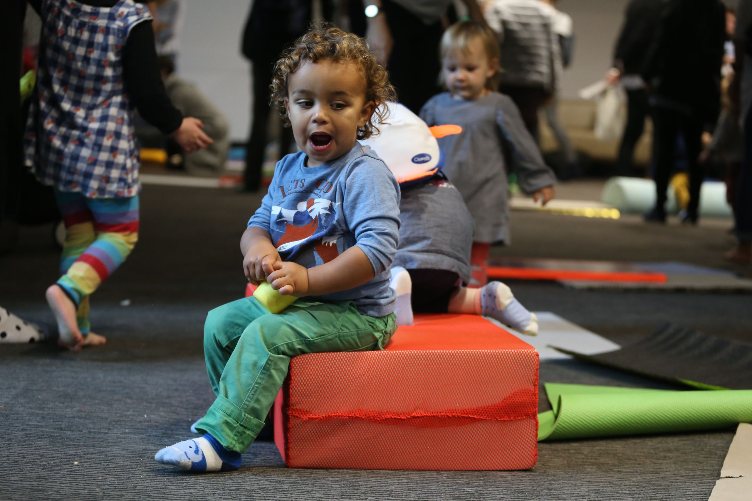 Baby sitting on a soft play block